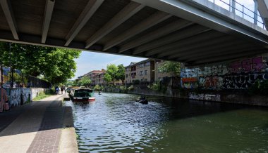 Londra - 06 04 2022: Regent 's Canal' daki Haggerston Köprüsü yakınlarındaki tren köprüsünün altından geçen kanolar