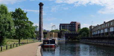 London - 06 04 2022: view of the Mile End Play Pavilion on the Regent's Canal with smokestack clipart