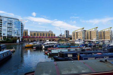 Londra - 06 04 2022: Limehouse rıhtımına demirlemiş yüzen evler ve gemiler ve arka planda DLR vagonları