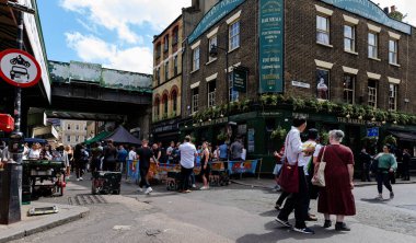 Londra - 06 10 2022: Sokaktaki insanlar ve Borough Market 'teki bir barın müşterileri.