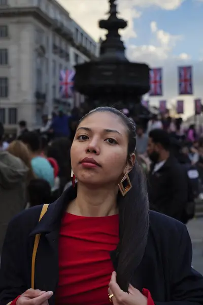 stock image London - 06 11 2022: Girl in Piccadilly Circus and the Shaftesbury Memorial Fountain in the background