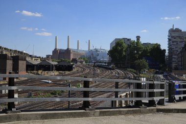 Londra - 06 14 2022: Arkadaki Battersea Elektrik Santrali ile Ebury Köprüsü 'nün altından geçen demiryolu hattından görüntü