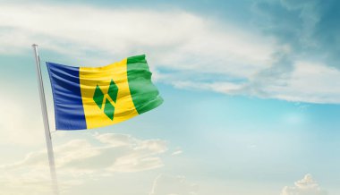 Saint Vincent and the Grenadines waving flag in beautiful sky.