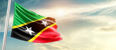 Saint Kitts and Nevis waving flag in beautiful sky with sun