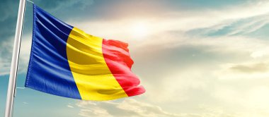 Romania waving flag in beautiful sky with sun