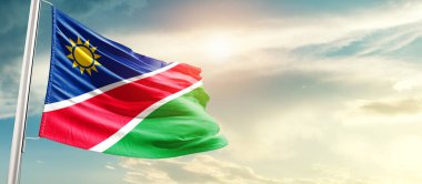 Namibia waving flag in beautiful sky with sun
