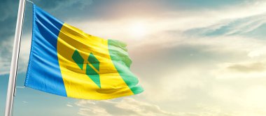 Saint Vincent and the Grenadines waving flag in beautiful sky with sun