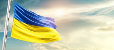 Ukraine waving flag in beautiful sky with sun