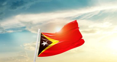 East Timor waving flag in beautiful sky with sun