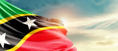 Saint Kitts and Nevis waving flag in beautiful sky with sun