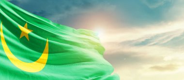 Mauritania waving flag in beautiful sky with sun