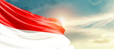 Indonesia waving flag in beautiful sky with sun
