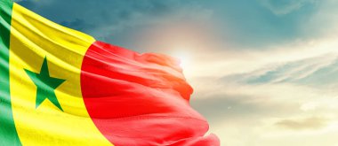 Senegal waving flag in beautiful sky with sun