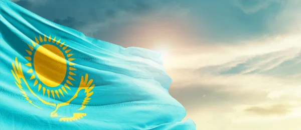Kazakhstan waving flag in beautiful sky with sun