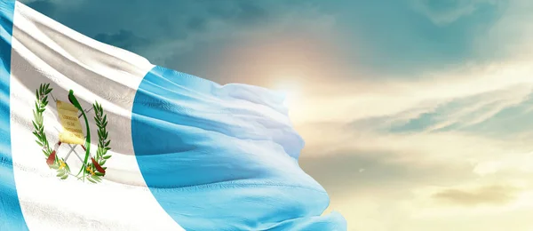 Stock image Guatemala waving flag in beautiful sky with sun