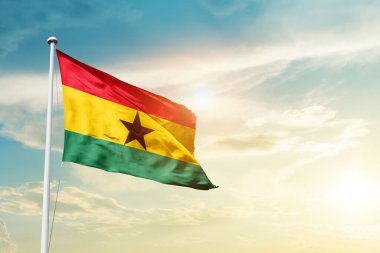 Ghana waving flag in beautiful sky with sun