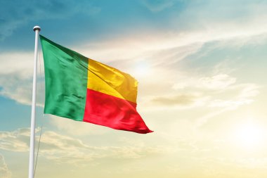 Benin waving flag in beautiful sky with sun