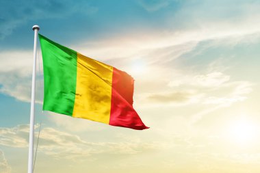 Mali waving flag in beautiful sky with sun