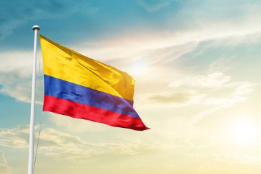 Colombia waving flag in beautiful sky with sun