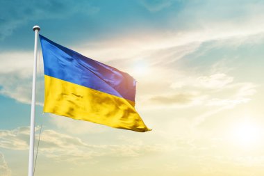 Ukraine waving flag in beautiful sky with sun