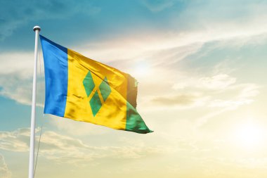 Saint Vincent and the Grenadines waving flag in beautiful sky with sun