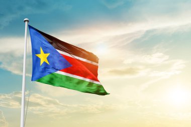 South Sudan waving flag in beautiful sky with sun