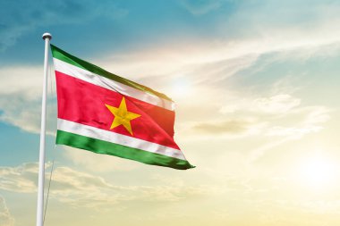 Suriname waving flag in beautiful sky with sun