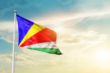 Seychelles waving flag in beautiful sky with sun