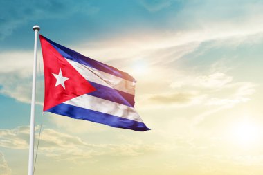 Cuba waving flag in beautiful sky with sun