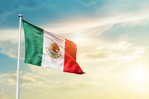 Mexico waving flag in beautiful sky with sun