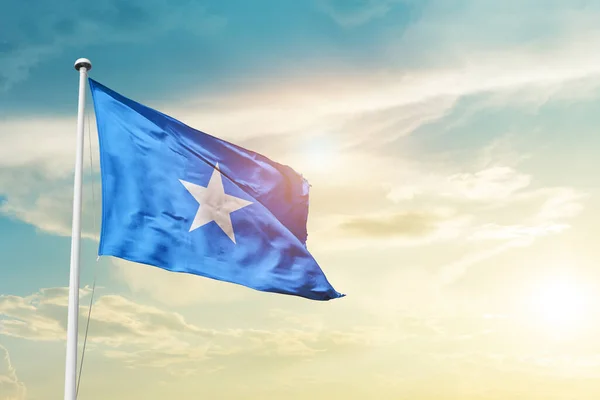 stock image Somalia waving flag in beautiful sky with sun