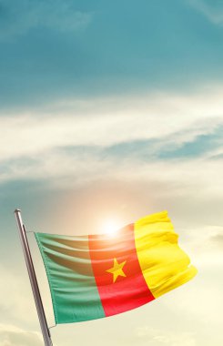 Cameroon waving flag in beautiful sky with sun