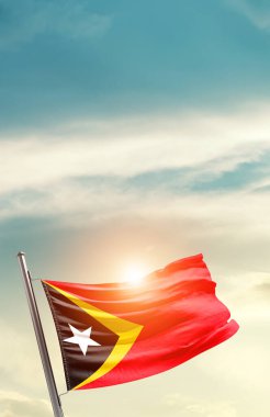 East Timor waving flag in beautiful sky with sun
