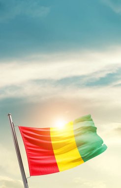 Guinea waving flag in beautiful sky with sun
