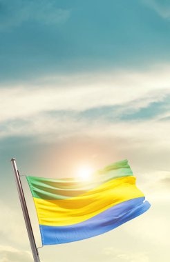Gabon waving flag in beautiful sky with sun