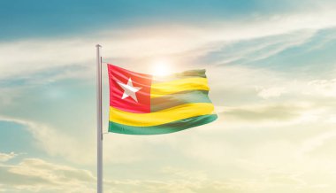 Togo waving flag in beautiful sky with sun