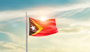 East Timor waving flag in beautiful sky with sun