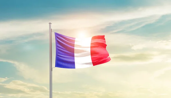 stock image France waving flag in beautiful sky with sun