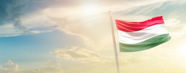 Hungary waving flag in beautiful sky with sun