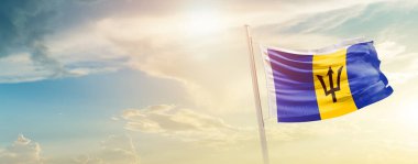 Barbados waving flag in beautiful sky with sun