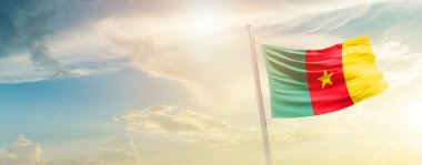 Cameroon waving flag in beautiful sky with sun