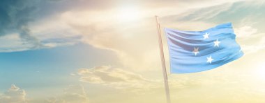 Micronesia waving flag in beautiful sky with sun