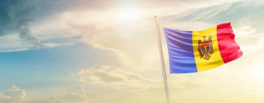 Moldova waving flag in beautiful sky with sun