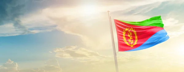 stock image Eritrea waving flag in beautiful sky with sun