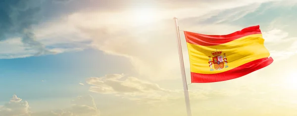 Spain waving flag in beautiful sky with sun