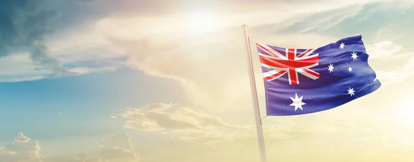 stock image Australia waving flag in beautiful sky with sun