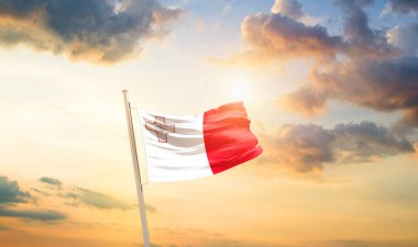 Malta bayrağı sallıyor bulutlar ve güneşle güzel gökyüzünde