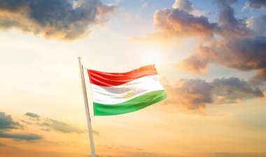 Tacikistan bulutlu ve güneşli güzel gökyüzünde bayrak sallıyor