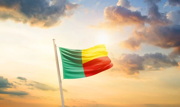 stock image Benin waving flag in beautiful sky with clouds and sun