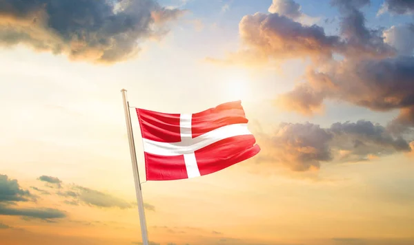 stock image Denmark waving flag in beautiful sky with clouds and sun